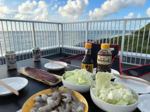 uma mesa com comida e bebidas numa varanda em AZ Hotel Ocean View em Sani