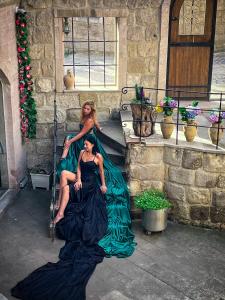 two women in long dresses sitting on a staircase at Salkım Cave House in Göreme