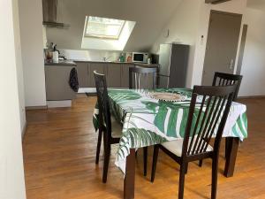 einen Esstisch mit einem grünen und weißen Tisch und Stühlen in der Unterkunft Appartement cosy in Massignieu-de-Rives