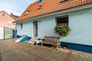 una casa blu con una panchina davanti di Ferienwohnung Blaues Haus a Ubstadt-Weiher