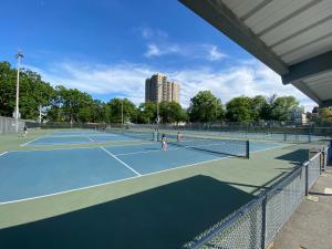 a group of people playing tennis on a tennis court at Cute Cozy 1 bedroom apartment 4 peoples 20 minutes to New York City in North Bergen