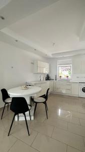 eine weiße Küche mit einem Tisch und 2 Stühlen in der Unterkunft Ferienwohnung & Apartment by KAYZ in Essen