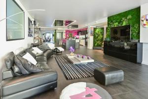 ein Wohnzimmer mit einem Sofa und einem Tisch in der Unterkunft Le Loft Oasis Prestige - Piscine et jacuzzi in Pringy