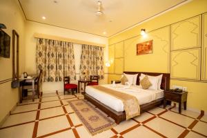 Habitación de hotel con cama y escritorio. en Laxmi Niwas, en Jaipur