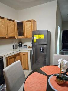 a kitchen with a table and a stainless steel refrigerator at SG Apartment Complex (Apt #1) in Linstead
