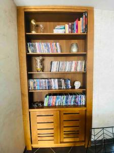 a wooden book shelf filled with dvds at Villa des Cloisieures in Saint-Amé