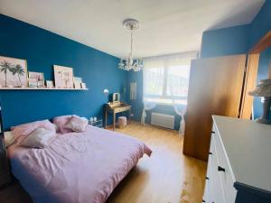 a bedroom with blue walls and a bed with pink sheets at Villa des Cloisieures in Saint-Amé