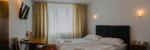 Una cama o camas en una habitación de Hotel Casa Pelerinul