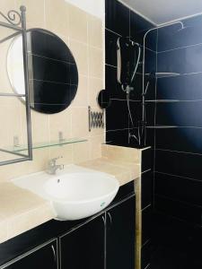 een badkamer met een witte wastafel en een spiegel bij FREE Wi-fi 100mbps I Emerald Cove Rawang in Rawang
