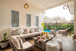 a living room with a couch and chairs and a table at LohonoStays Villa Sobreda in Bardez
