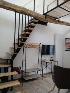 una scala in un loft con scrivania e TV di Lebeau Repos a Plouër-sur-Rance