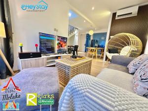 マラッカにあるTheWave Residence By Heystay Managementのベッドルーム(ベッド1台、大画面テレビ付)