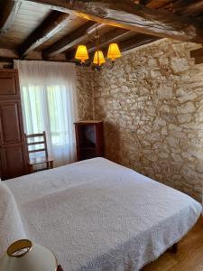 1 dormitorio con cama blanca y pared de piedra en La casa de Aza, en Haza 31 fotos más