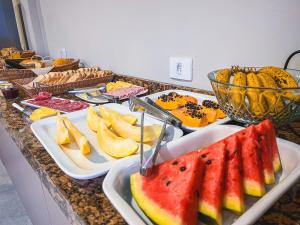 - un buffet de plats avec des fruits sur une table dans l'établissement Hotel Gold Ville, à Siqueira Campos