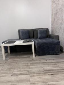 - un canapé noir avec une table et une table blanche dans l'établissement Modern & Elegant Luxury Apartament, à Craiova