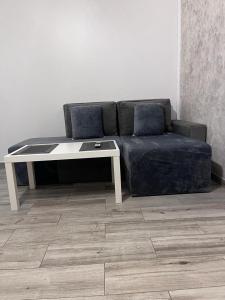 een zwarte bank met een tafel en een witte tafel bij MODERN & ELEGANT Apartament in Craiova
