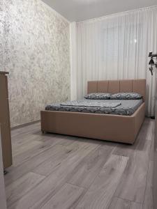 een slaapkamer met een bed en een houten vloer bij MODERN & ELEGANT Apartament in Craiova