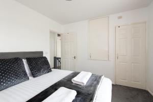 a bedroom with a bed with black and white sheets at The Crescent in Witton Gilbert