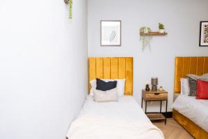 1 Schlafzimmer mit 2 Betten und Kissen in der Unterkunft Peaceful home Nr Roundhay Park in Moortown