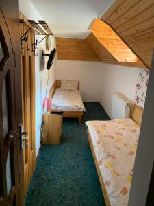 Hypnotic Villa Predeal في بريدال: غرفة صغيرة بسريرين في غرفة