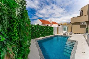 a swimming pool in a yard next to a fence at BAL Apartments Adults Only in Arona