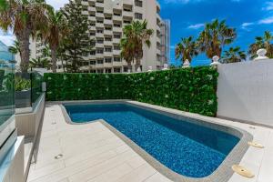 a swimming pool next to a fence and a building at BAL Apartments Adults Only in Arona