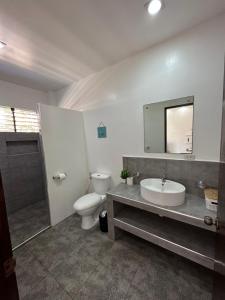 uma casa de banho com um lavatório, um WC e um espelho. em Panglao Bamboo Oasis em Panglao