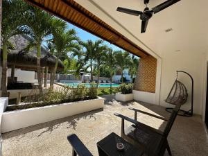 a patio with a hammock and a swimming pool at Panglao Bamboo Oasis in Panglao