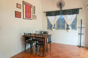comedor con mesa, sillas y ventana en Baan Ragang : Cozy Entire House in Old Chiang Mai en Chiang Mai