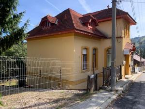 Hypnotic Villa Predeal في بريدال: منزل اصفر صغير امامه سياج