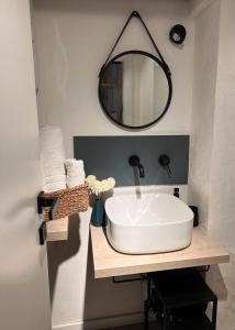 un bagno con un lavandino bianco e uno specchio di CasaCecè kalsa a Palermo