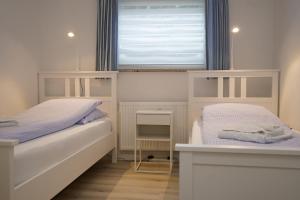 um pequeno quarto com 2 camas e uma janela em Yildirim Touristik Wohnung L&L 7 em Duhnen