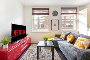 sala de estar con sofá y TV en Luxury Central London Apartment - Farringdon, en Londres