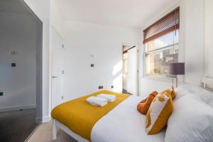 1 dormitorio con 1 cama grande con manta amarilla en Luxury Central London Apartment - Farringdon, en Londres