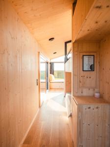 a small house with wooden walls and wood flooring at Auszeit Tollensesee in Groß Nemerow +20 photos