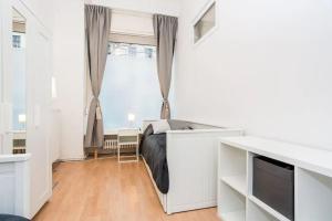 Habitación blanca con cama y ventana en Newly furnished apartment for up to 6 people, en Berlín