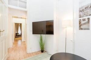 sala de estar con TV de pantalla plana en una pared blanca en Newly furnished apartment for up to 6 people, en Berlín