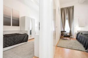 Un dormitorio blanco con 2 camas y una silla en Newly furnished apartment for up to 6 people, en Berlín