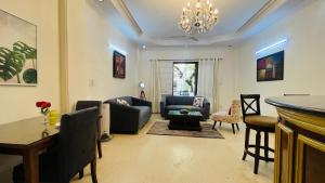sala de estar con sofá, mesa y sillas en Olive Service Apartments - Greater Kailash, en Nueva Delhi