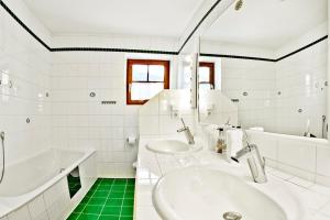 uma casa de banho branca com 2 lavatórios e uma banheira em ZugspitzApps em Ehrwald