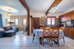 uma cozinha e sala de estar com mesa e cadeiras em Casa del Mar II by GALMI em Arco de São Jorge