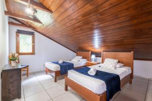 um quarto com 2 camas e um tecto de madeira em Casa del Mar II by GALMI em Arco de São Jorge