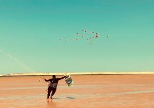 Un homme debout sur une plage volant un cerf-volant dans l'établissement PARAISO DAKHLA, à Dakhla