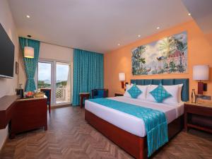 Cette chambre comprend un grand lit et une fenêtre. dans l'établissement Daiwik Hotels Rameswaram, à Rameswaram