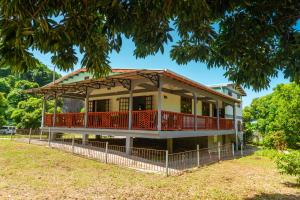 a house with a wrap around porch and a balcony at Maison de Lecointe in Dublanc