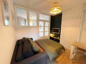 ein Wohnzimmer mit einem Sofa und einem Fenster in der Unterkunft Chez Elo in Tours