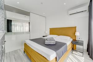a bedroom with a large bed with towels on it at BAL Apartments Adults Only in Arona