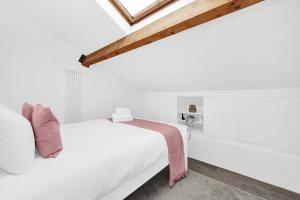 a white bedroom with a bed and a wooden ceiling at Large Industrial Style 2 Bedroom Flat! in London