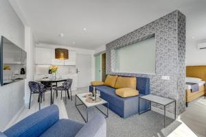 a living room with a blue couch and a bed at BAL Apartments Adults Only in Arona