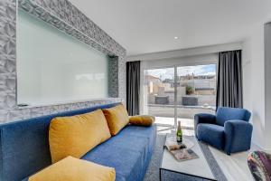 a blue couch and a chair in a living room at BAL Apartments Adults Only in Arona